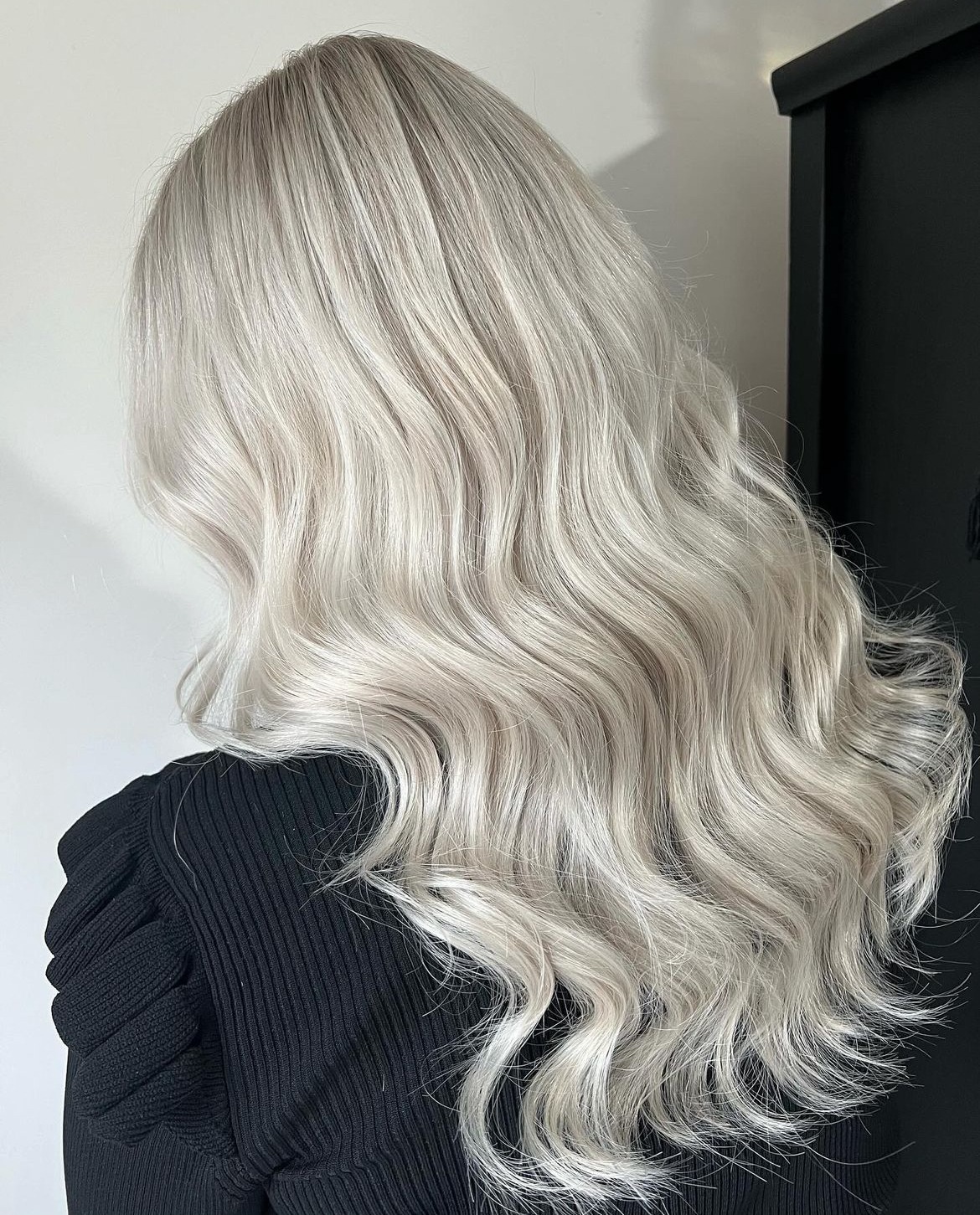 Zilverblond haar in lange golven, van achteren gezien