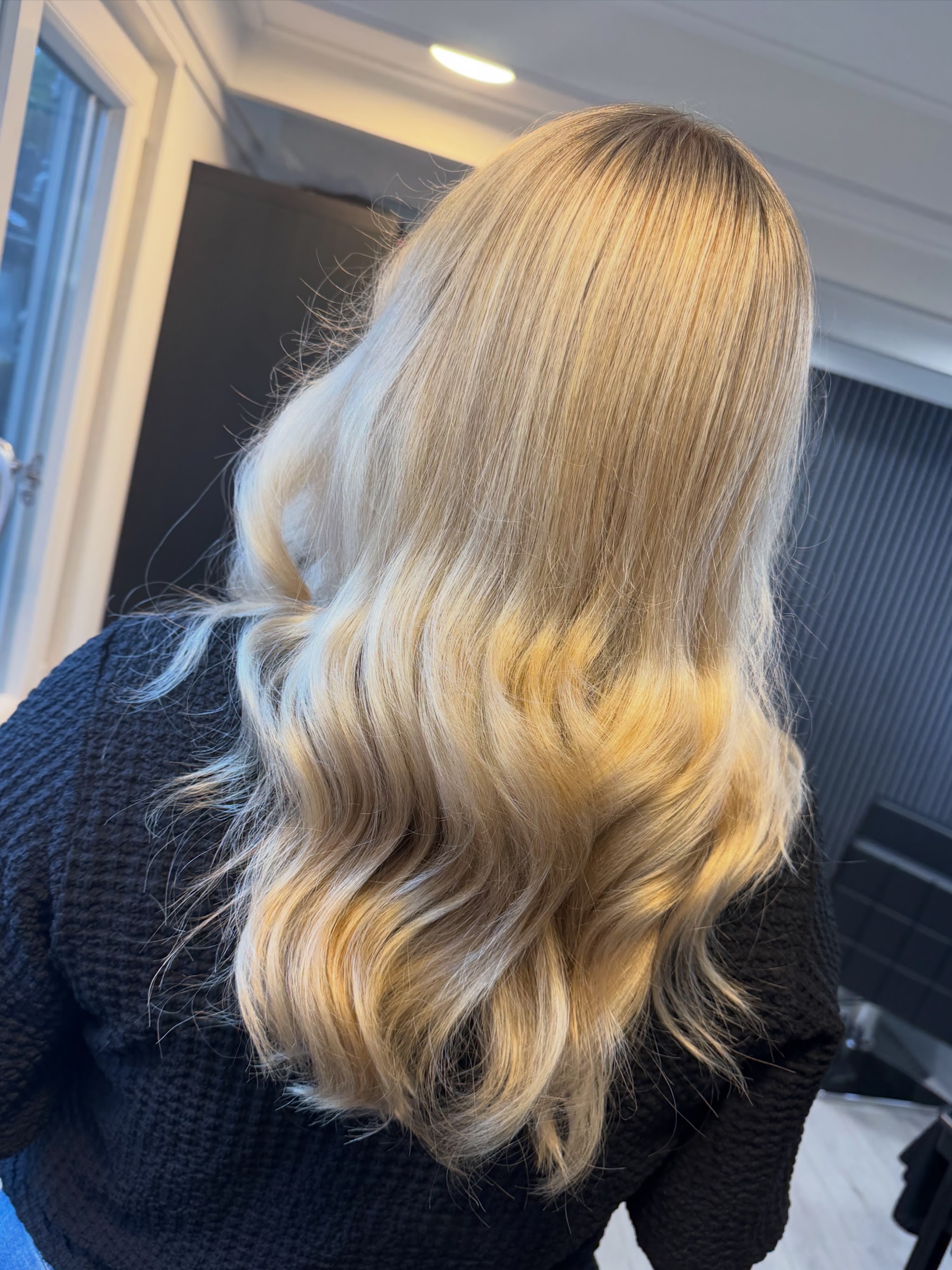 Blond haar met warme gouden punten in golven, van achteren gezien