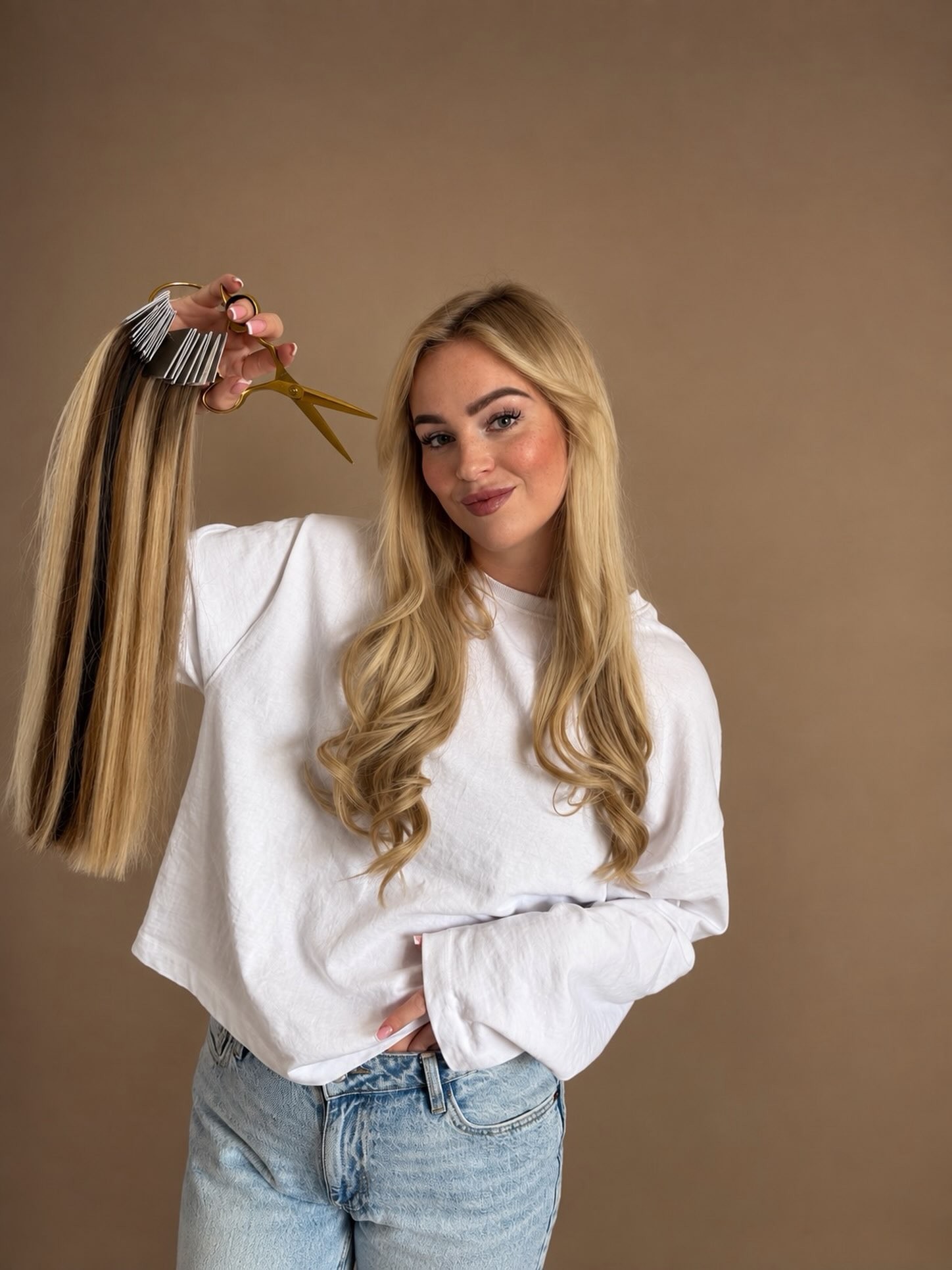 Britt, eigenaresse van May Blonde, met een schaar en een bundel extensions in haar hand